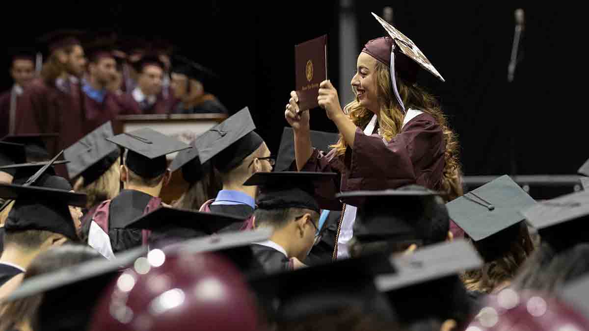 Student displays diploma at commencement