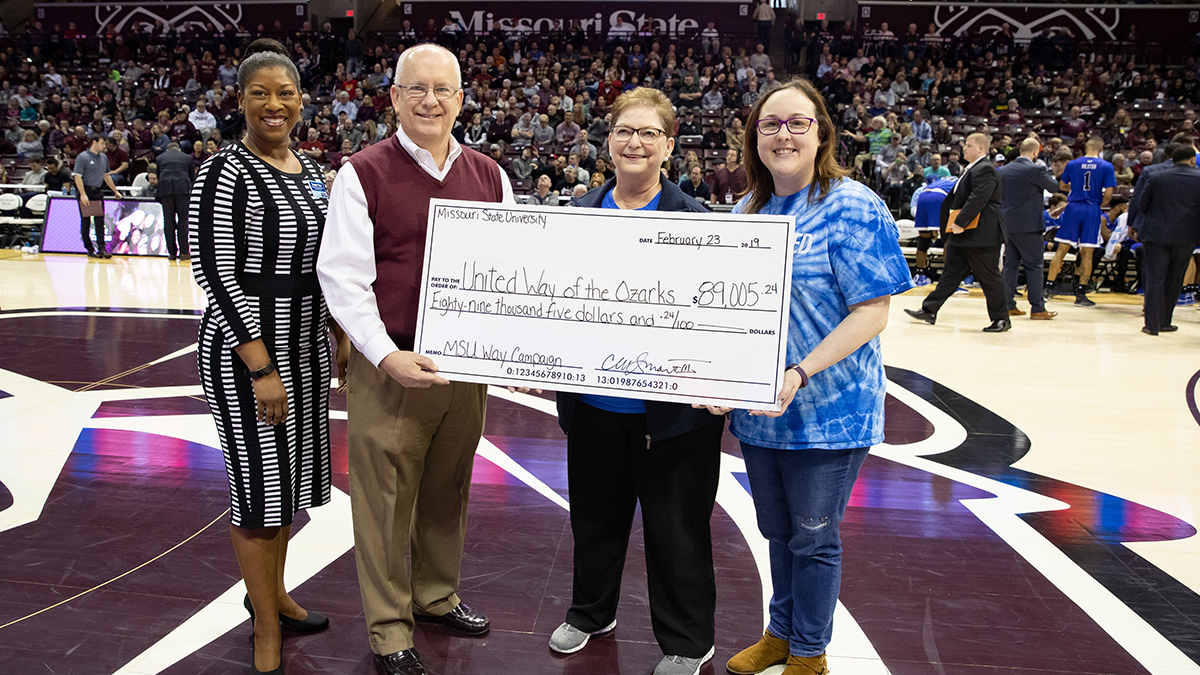 President Smart and Tammy Few present check to United Way at MSU basketball game