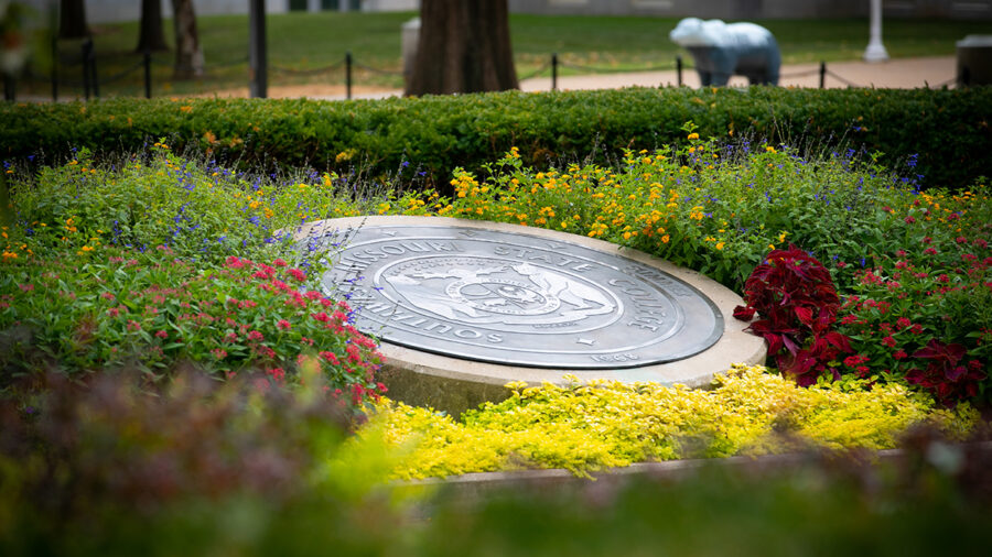 University seal surrounded by flowers
