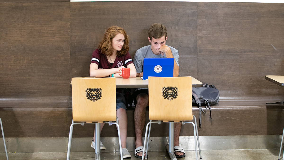 Two students share laptop
