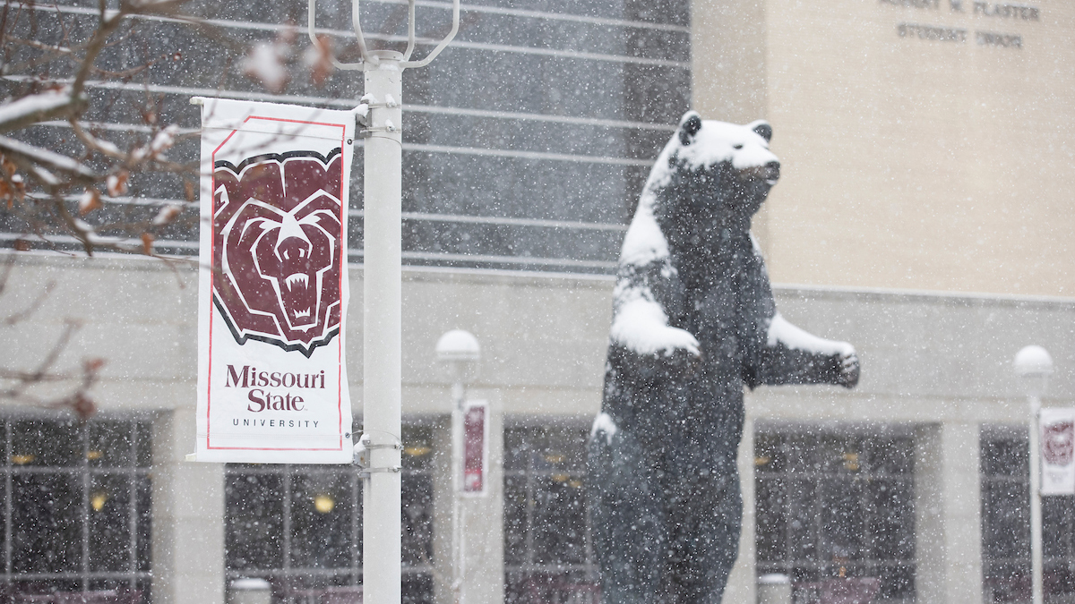 Snow falls on Bear statue outside of PSU.