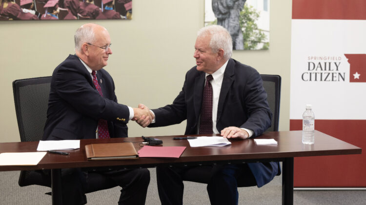 Clif Smart and Tom Carlso shake hands at signing of agreement with Daily Citizen.