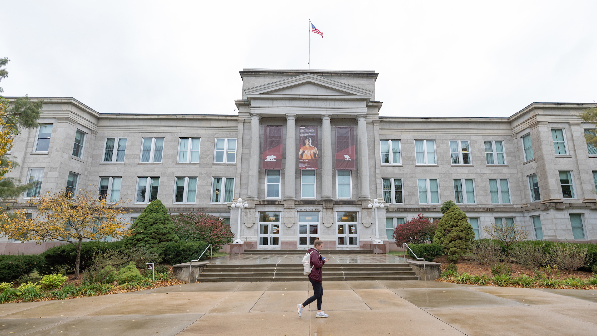 Female Missouri State student walks in front of Carrington.
