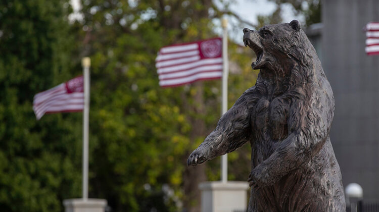 The Plaster Stadium Bear statue with Missouri State flags in the background.