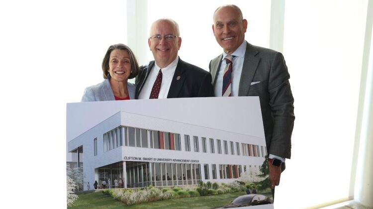 Clif and Gail Smart and Brent Dunn hold a rendering of the Clifton M. Smart III Advancement Building