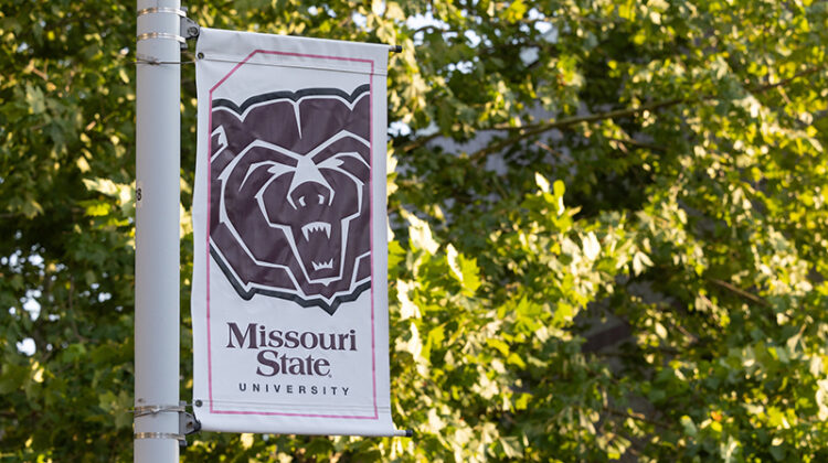 A Bear head logo banner on campus.