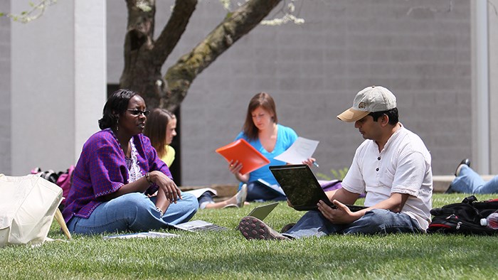 students sitting on grass