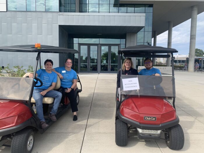 School of Accountancy students smiling in golf cars at the IMA Heartland Council Education Conference, where the students served as volunteers.