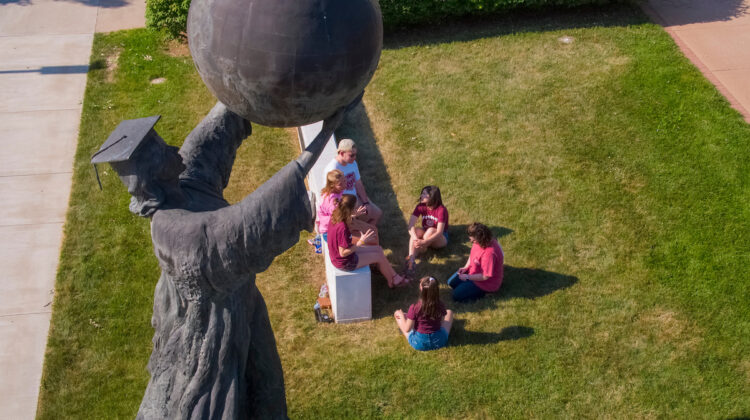 Missouri State's Citizen Scholar statue, as seen from above, with students sitting in the background.