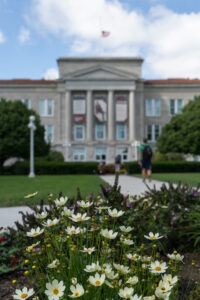 Missouri State's Carrington Hall on a spring day, with flowers in the foreground. 