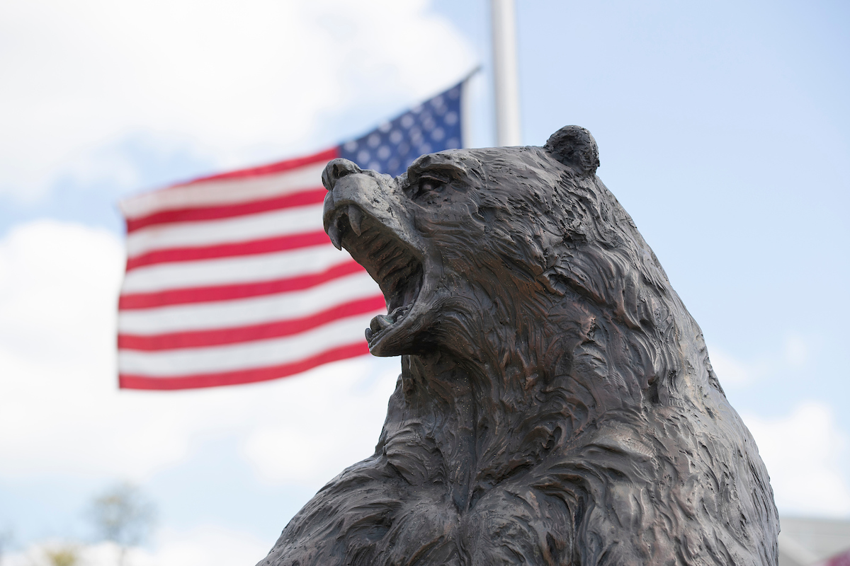 A Bear Statue at Missouri State, in front of the American flag