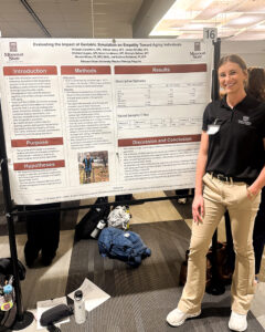 Student standing with her research presentation at the MCHHS Student Research Symposium.