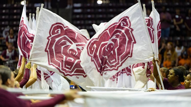 Mo State students carrying maroon and white Bear head flags at New Student Convocation.
