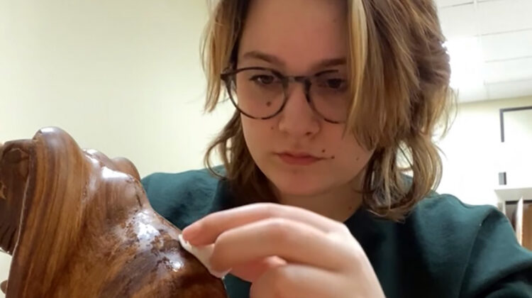 Student cleans artifact