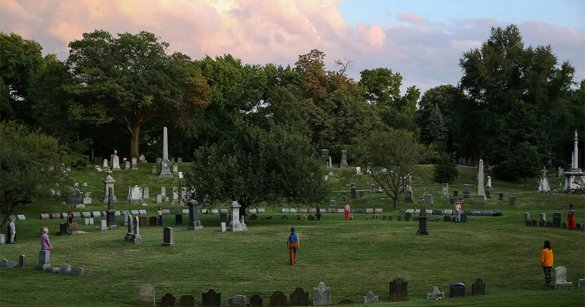 People standing in a circle in a cemetery
