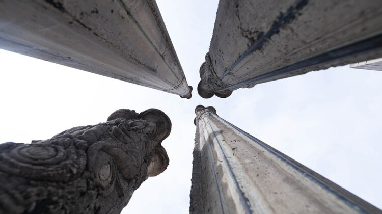 View looking up at 4 concrete column sculptures