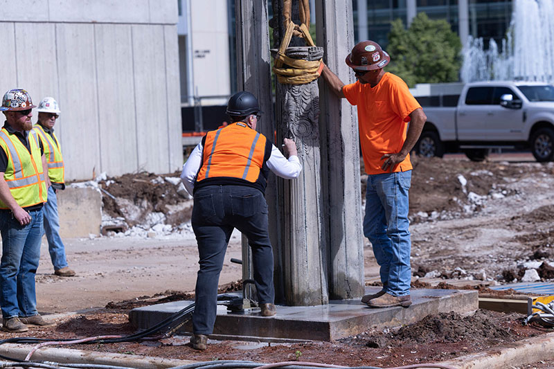 Four construction workers look at sculpture