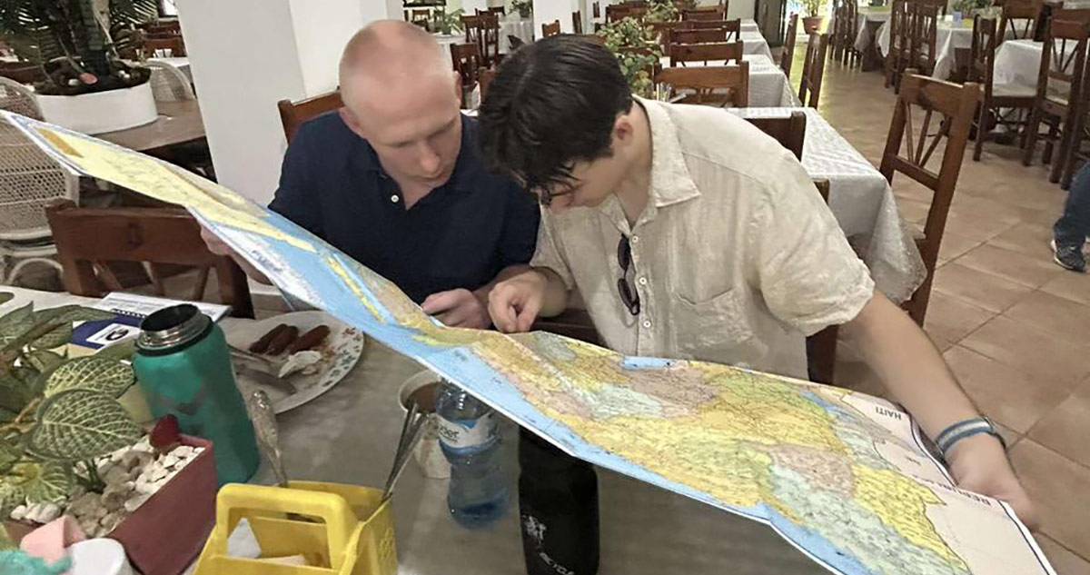 Two individuals at table looking at map