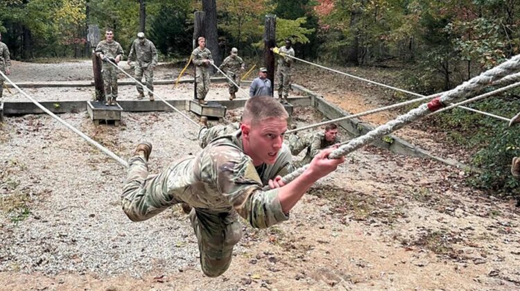 Individual military person climbing rope