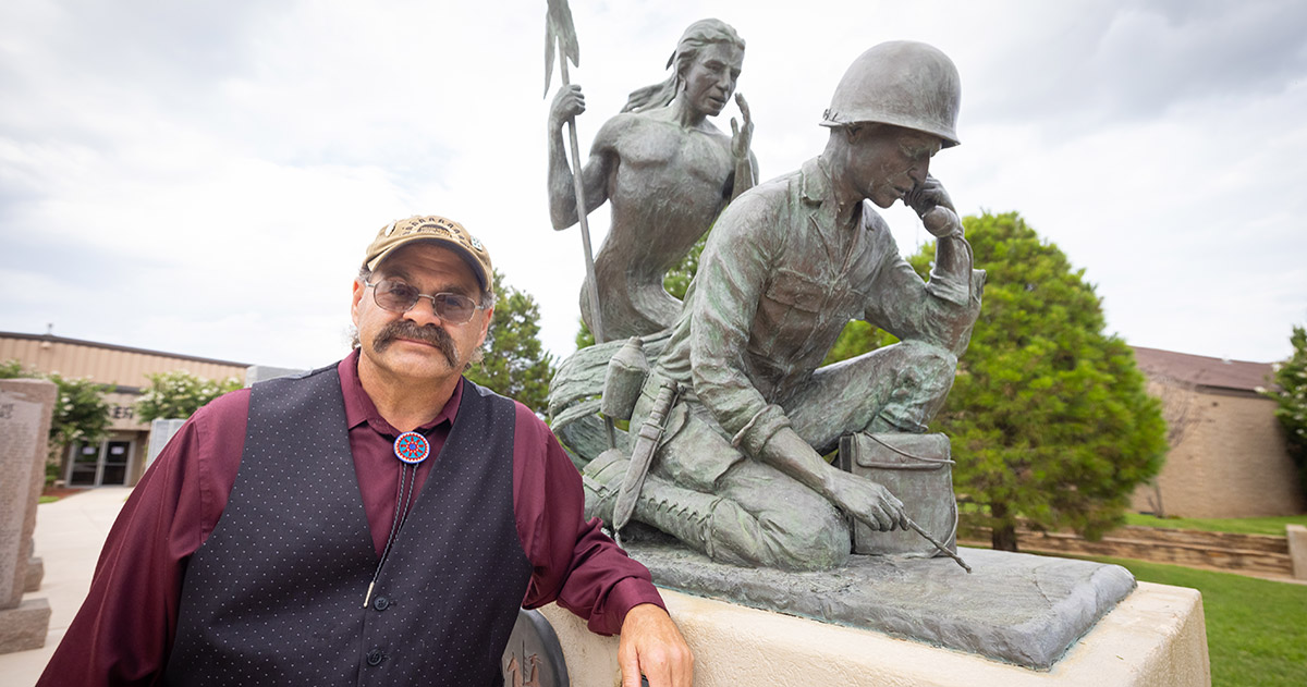 Professor Meadows poses with statue of Native American code talkers