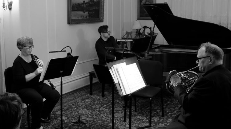 Three musicians playing oboe, piano, and cello