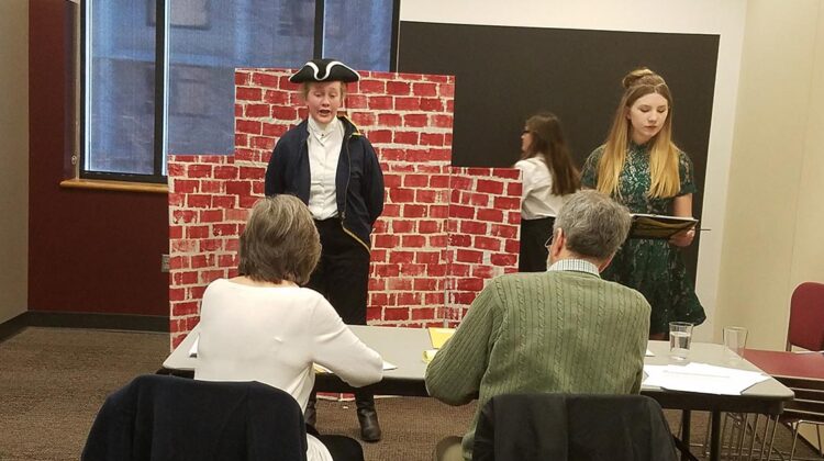 Two children performing a skit for two adults