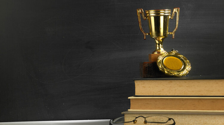 Trophy on stack of books in front of blackboard
