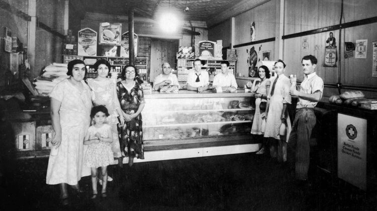 Several adults and a child standing in front of store counter
