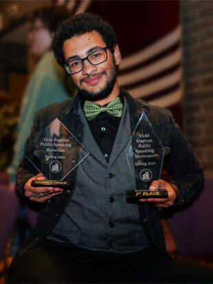 Young man holds two awards