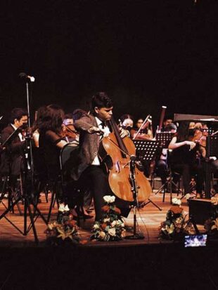 Young man on stage playing cello