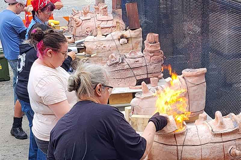 Students working with small ceramic kilns.