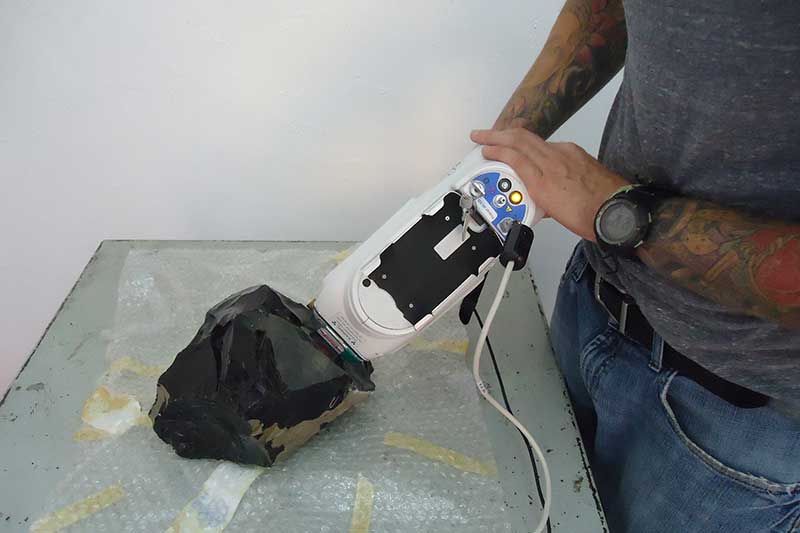 Close up of individual holding x-ray archaeology equipment