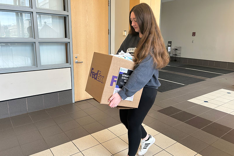Young woman carrying donation box