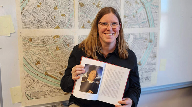 Woman smiling and holding open book