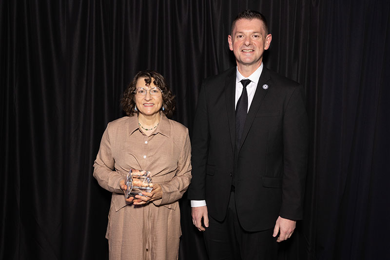 Man and woman with woman holding award