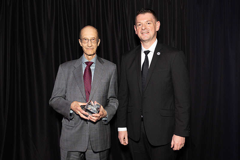 Two men with one man holding award