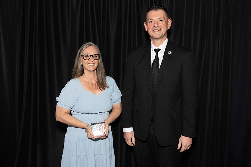 Man and woman with woman holding an award