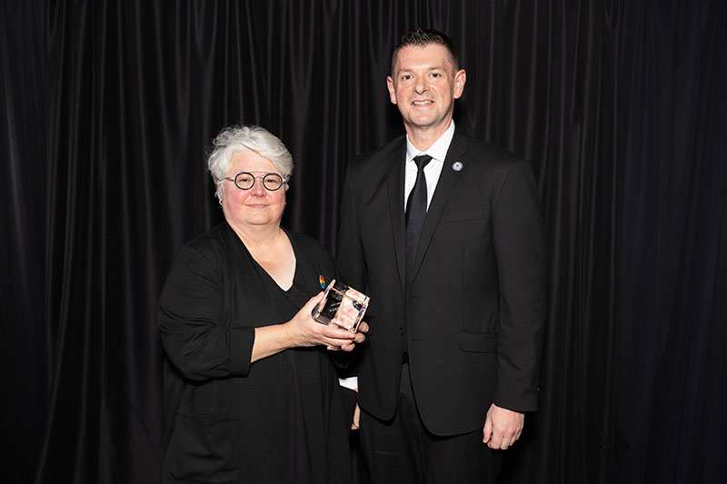 Man and woman with woman holding award