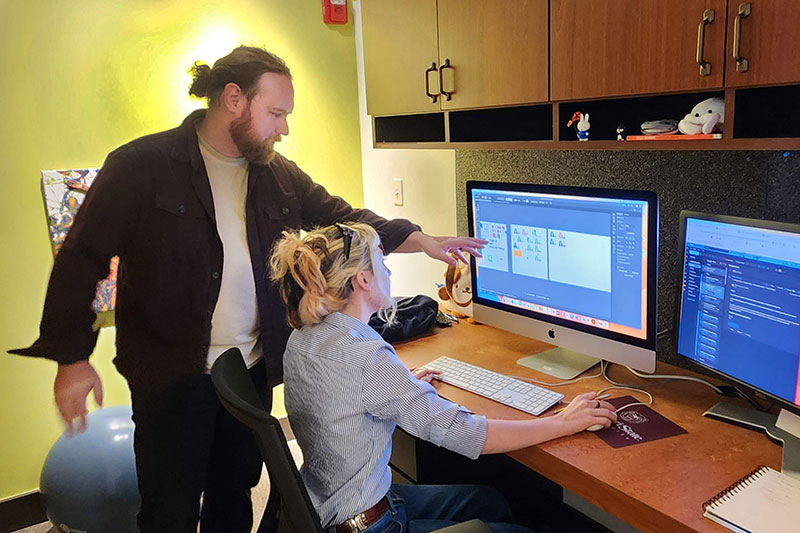 Man explaining digital project to student