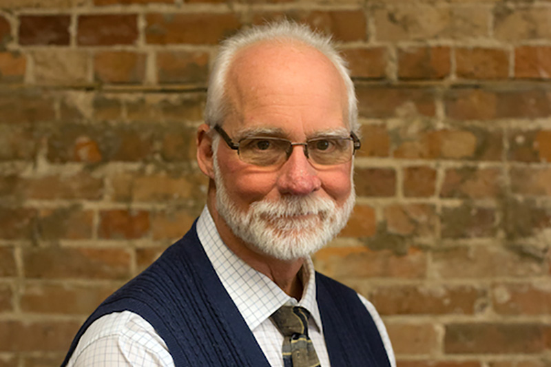 Close up of man standing in front of brick wall