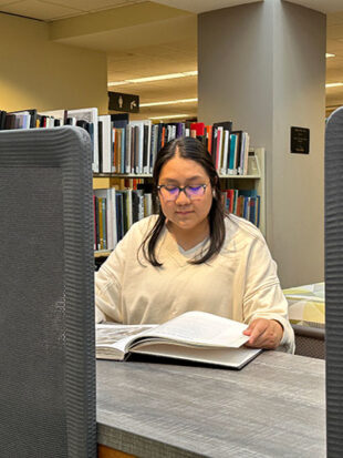 Young woman sitting in library reading