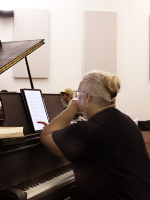 Woman sitting at piano during rehearsal