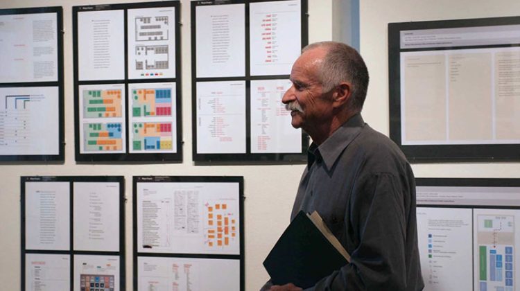 Profile of man standing in front of artwork
