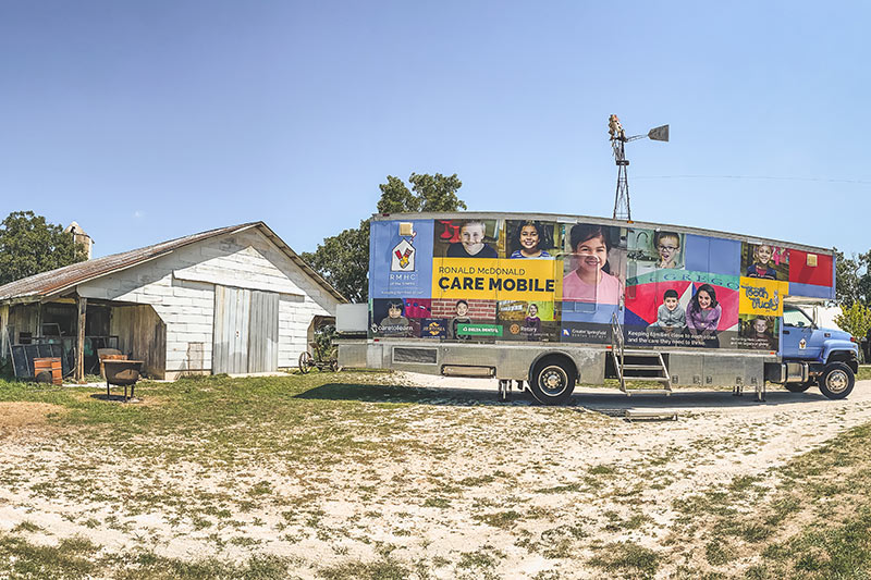 Dental bus in front of rural buildings