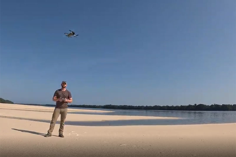 Man standing outside operating a drone