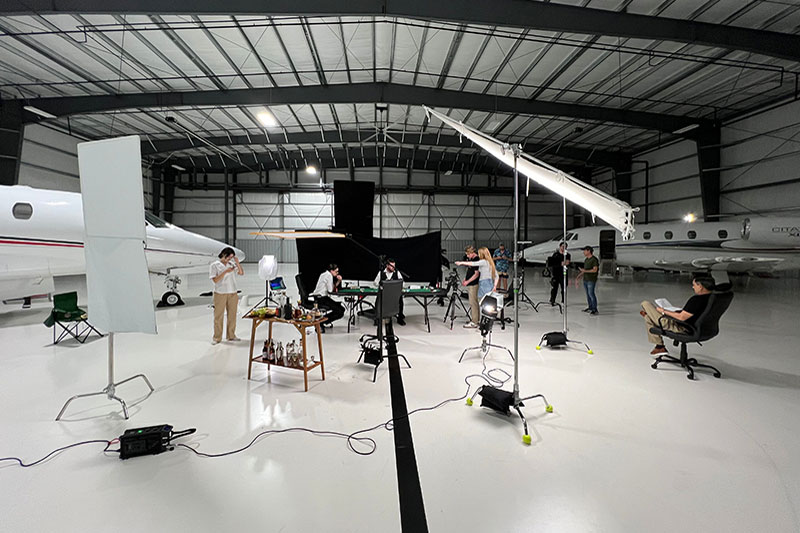Filmmakers on set in airport hanger