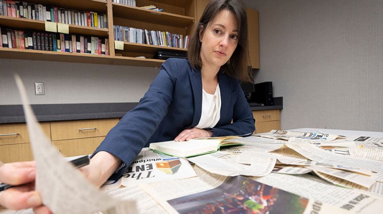 Dr. Laura Hart, associate professor of sociology, examines papers at her desk in her office.