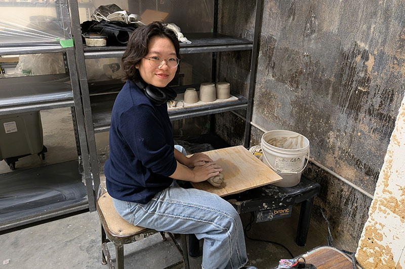 Young woman working at ceramic table