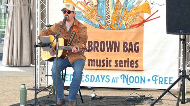 Man with guitar on amphitheatre stage