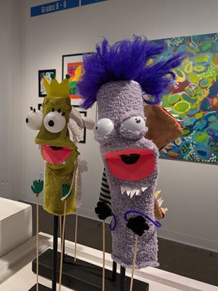 Close up of puppet-like sculptures with google eyes in an art gallery
